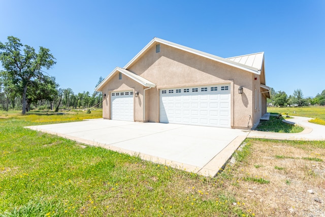 view of side of property with a lawn and a garage