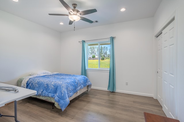 bedroom with hardwood / wood-style floors, a closet, and ceiling fan