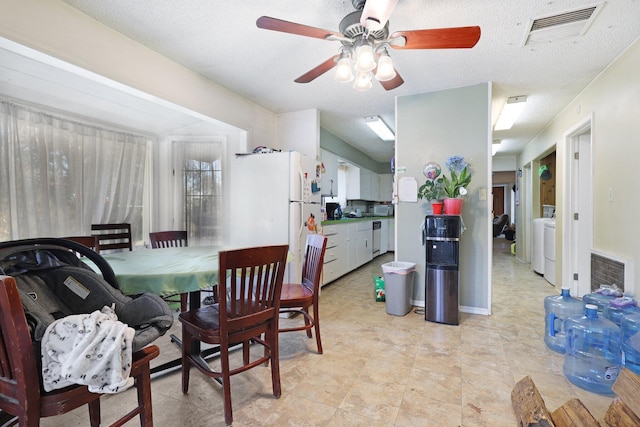 dining space featuring washing machine and clothes dryer, ceiling fan, and a textured ceiling