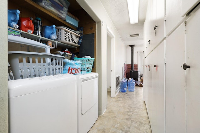 laundry area featuring a textured ceiling and washing machine and clothes dryer