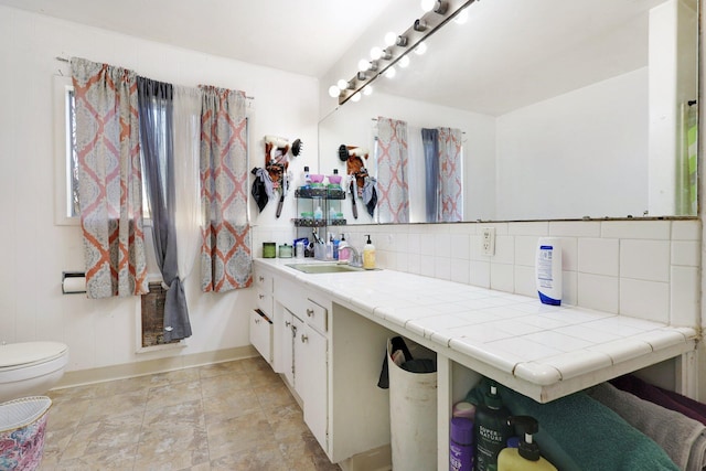 bathroom featuring vanity, tasteful backsplash, and toilet