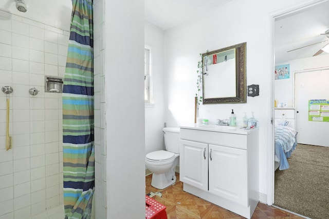 bathroom with vanity, ceiling fan, toilet, and curtained shower