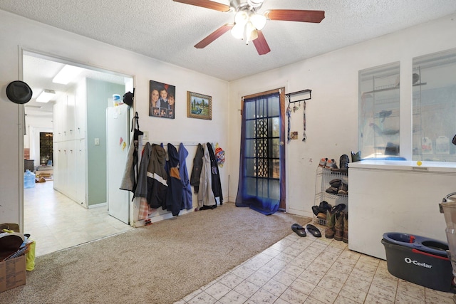 misc room with a textured ceiling, light colored carpet, and ceiling fan