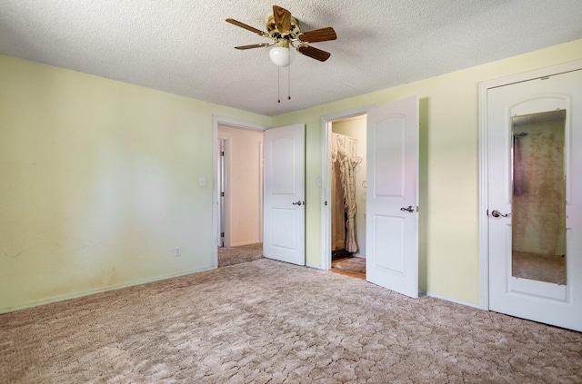 unfurnished bedroom featuring ceiling fan, light colored carpet, and a textured ceiling