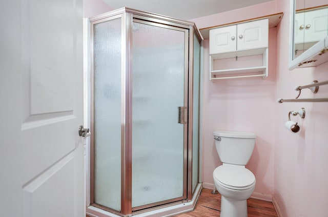 bathroom featuring hardwood / wood-style floors, toilet, and walk in shower