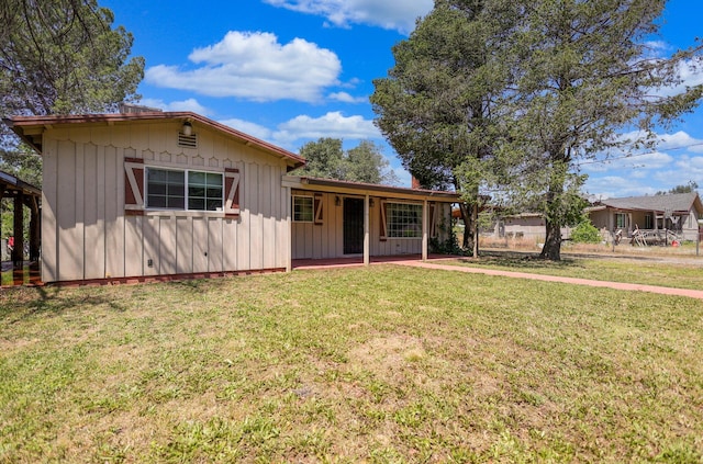 ranch-style house featuring board and batten siding and a front yard