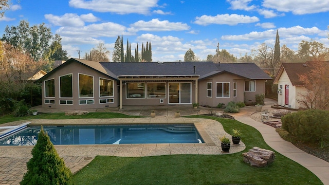 back of property featuring a lawn and a patio