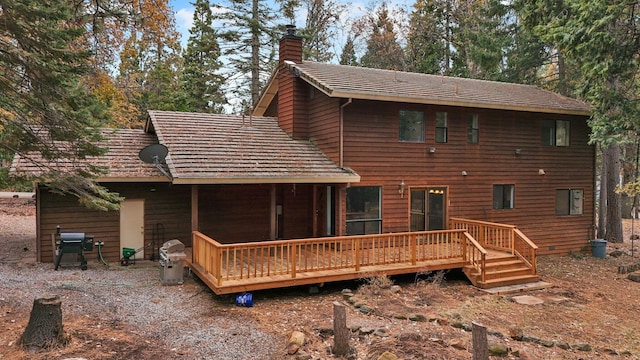 rear view of house featuring a wooden deck