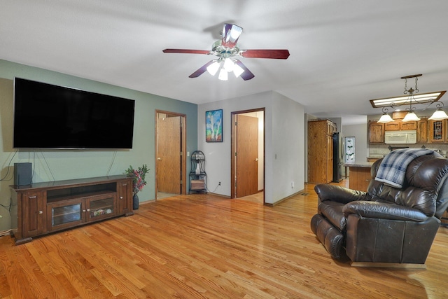 living room featuring ceiling fan and light hardwood / wood-style floors