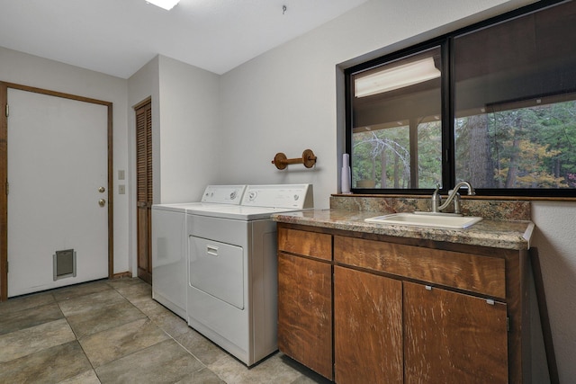 washroom featuring cabinets, sink, and washer and dryer