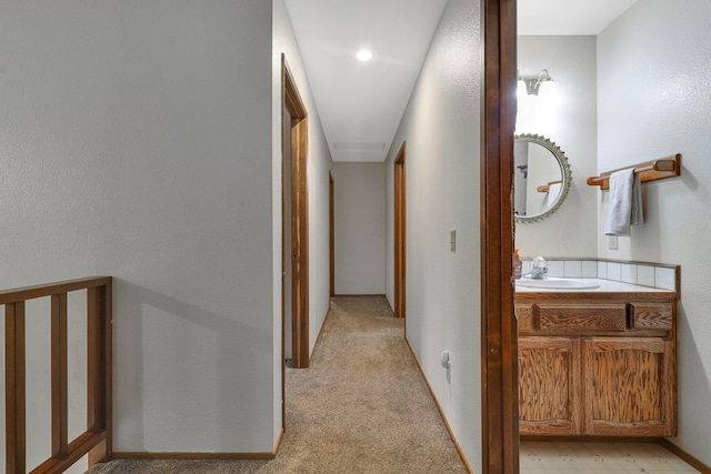 corridor with light colored carpet and sink