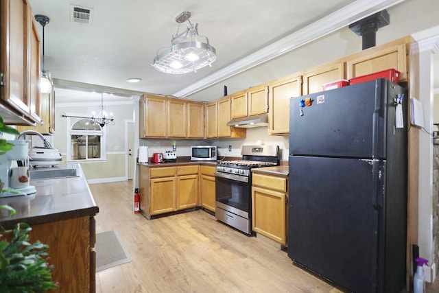 kitchen featuring light wood-type flooring, ornamental molding, stainless steel appliances, a chandelier, and hanging light fixtures