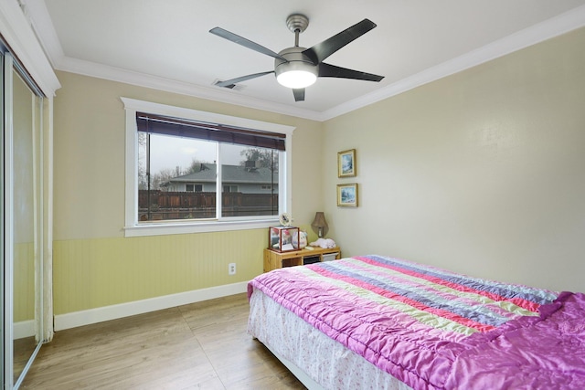 bedroom with ceiling fan, crown molding, and a closet