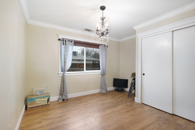 bedroom featuring hardwood / wood-style flooring, a notable chandelier, ornamental molding, and a closet