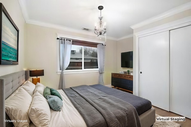 bedroom with ornamental molding, a closet, and a notable chandelier