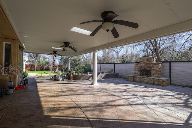 view of patio with an outdoor stone fireplace and ceiling fan