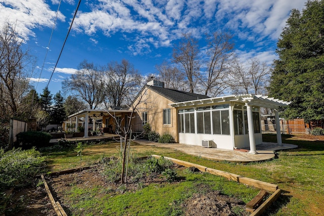 rear view of house featuring a pergola, central AC, a sunroom, and a lawn