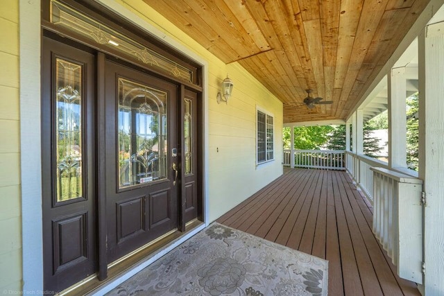 view of exterior entry featuring ceiling fan and a porch