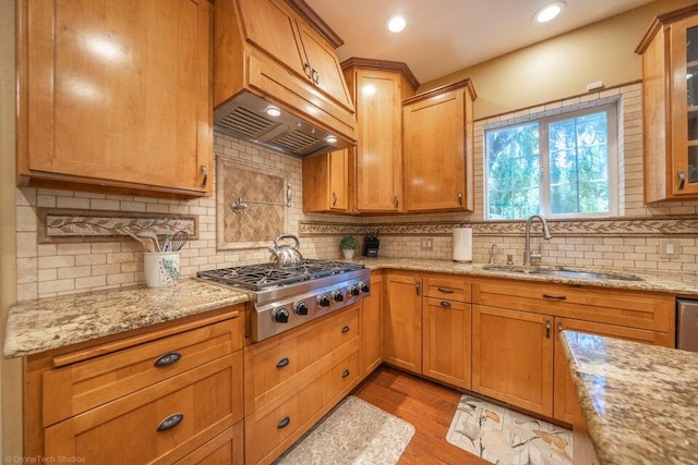 kitchen featuring light stone countertops, light hardwood / wood-style floors, stainless steel gas cooktop, and sink