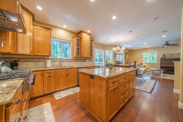 kitchen featuring dark hardwood / wood-style flooring, decorative light fixtures, a kitchen island, and a wealth of natural light