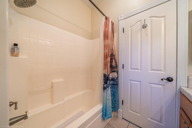 bathroom featuring tile patterned flooring, vanity, and shower / bath combo with shower curtain