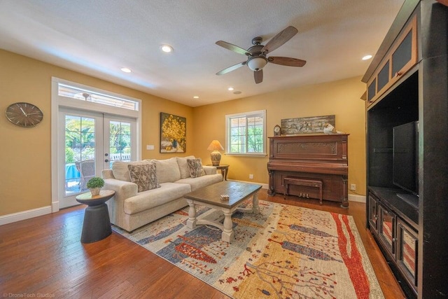 living room with plenty of natural light, ceiling fan, dark hardwood / wood-style flooring, and french doors