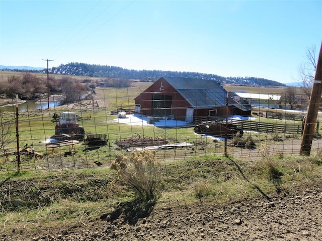 view of yard with an outbuilding, a rural view, and a water view