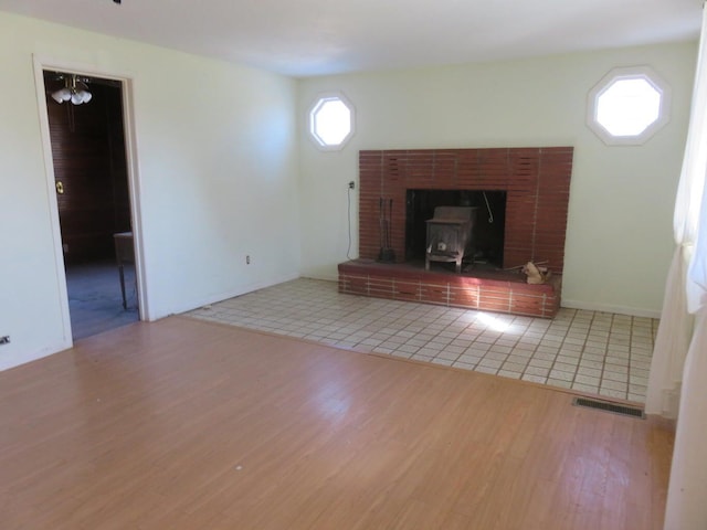 unfurnished living room featuring a wood stove and wood-type flooring