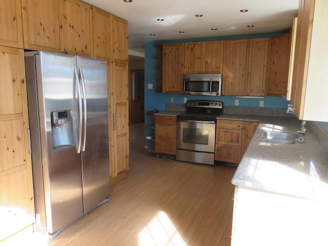 kitchen featuring sink, light wood-type flooring, and appliances with stainless steel finishes