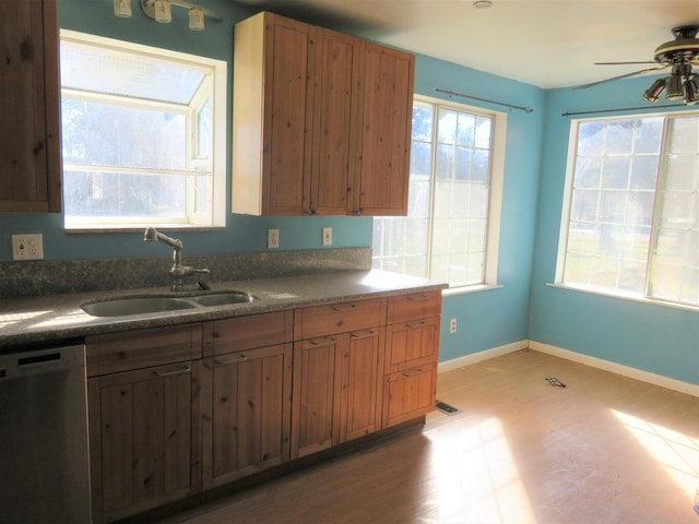 kitchen featuring stainless steel dishwasher, ceiling fan, light wood-type flooring, and sink