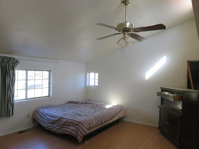 bedroom featuring hardwood / wood-style floors, multiple windows, and ceiling fan