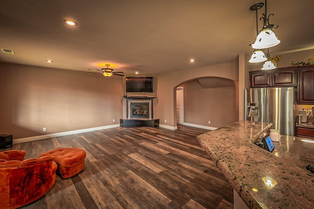 living room with ceiling fan and dark hardwood / wood-style flooring