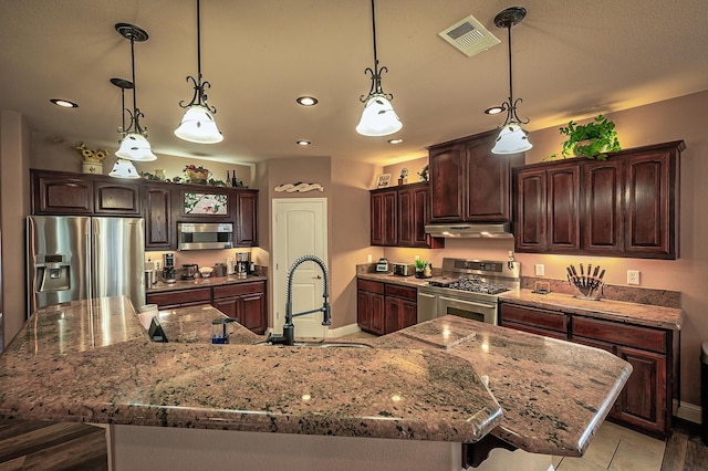 kitchen with appliances with stainless steel finishes, dark brown cabinetry, a spacious island, and sink