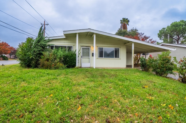 view of front of house with a front yard and a carport