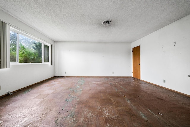 spare room featuring hardwood / wood-style flooring and a textured ceiling