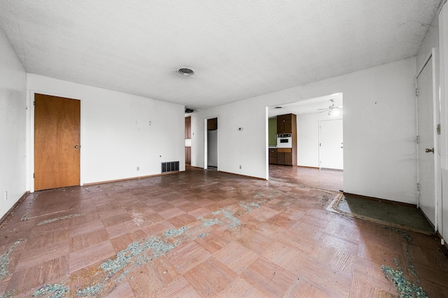 empty room featuring a textured ceiling and ceiling fan