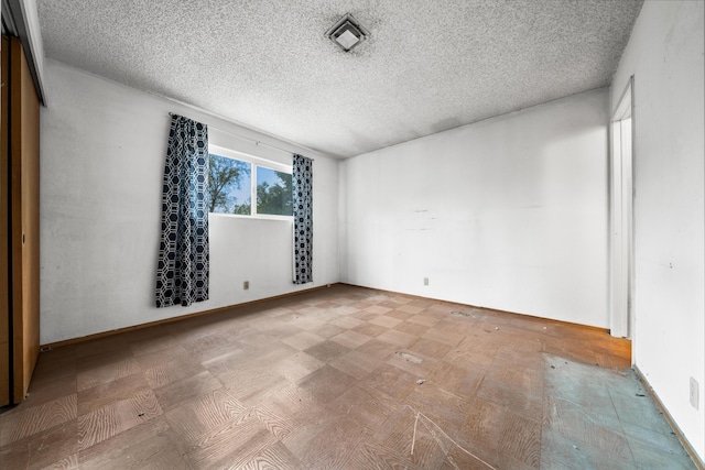 unfurnished room featuring a textured ceiling