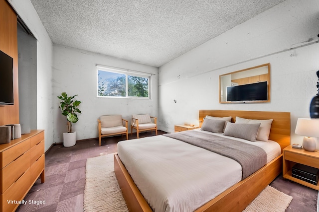 bedroom featuring a textured ceiling, vaulted ceiling, and a closet