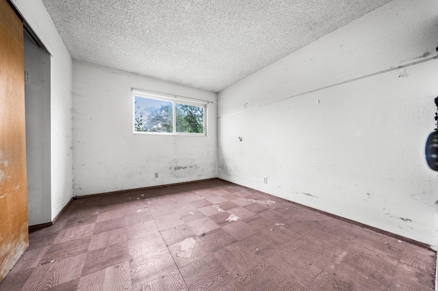 spare room with vaulted ceiling and a textured ceiling