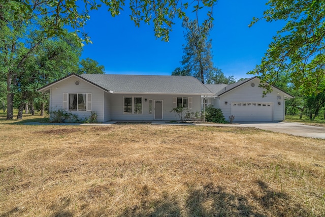 ranch-style home featuring covered porch, a garage, and a front yard