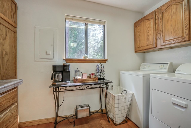 washroom with cabinets, washer and clothes dryer, and hardwood / wood-style floors