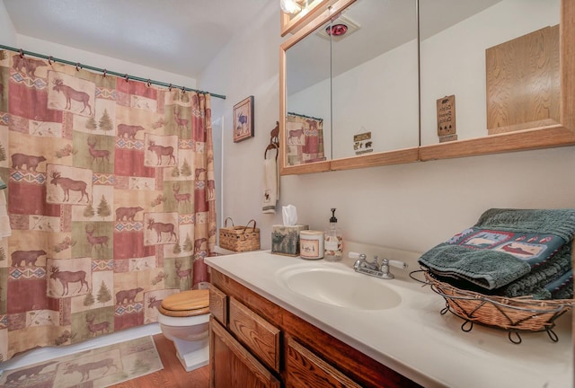 bathroom featuring vanity, curtained shower, toilet, and wood-type flooring