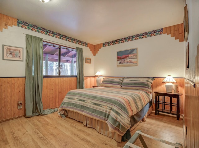 bedroom featuring hardwood / wood-style flooring and wood walls