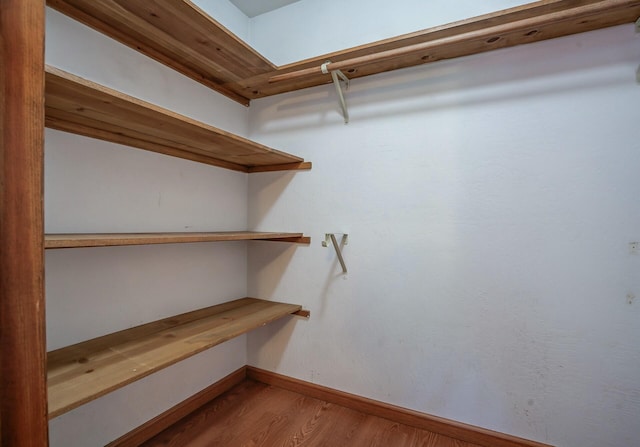 walk in closet with hardwood / wood-style floors