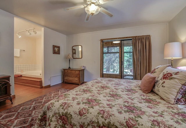 bedroom with access to exterior, wood-type flooring, rail lighting, and ceiling fan