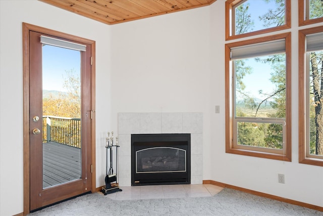 unfurnished living room featuring a fireplace, a wealth of natural light, and wooden ceiling