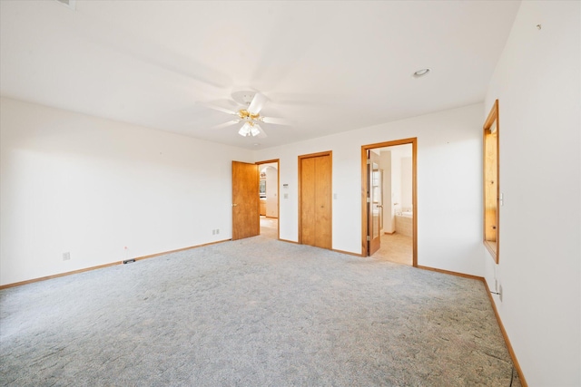 unfurnished bedroom featuring light carpet, connected bathroom, and ceiling fan