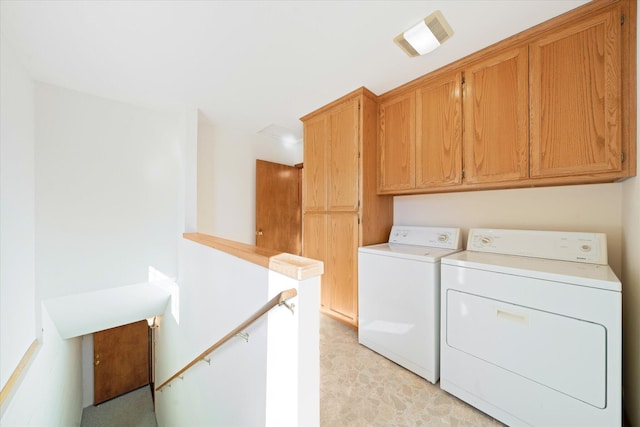 washroom featuring cabinets, light colored carpet, and washer and clothes dryer