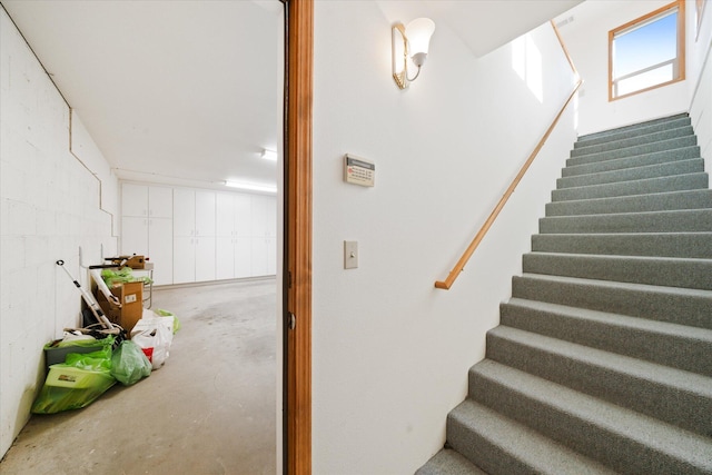 staircase featuring concrete floors