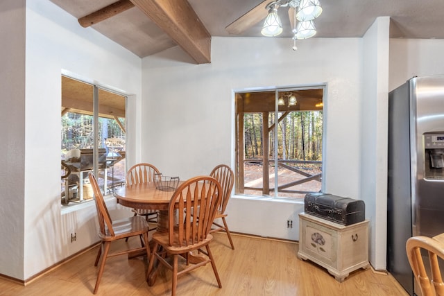 dining room featuring beamed ceiling, light wood-type flooring, plenty of natural light, and ceiling fan